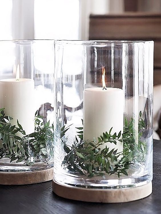 Just a bit of greenery placed in hurricane jars takes simple white candles from basic to festive.