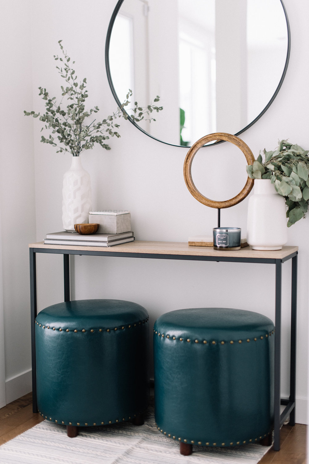 front entry table with round mirror and ottomans