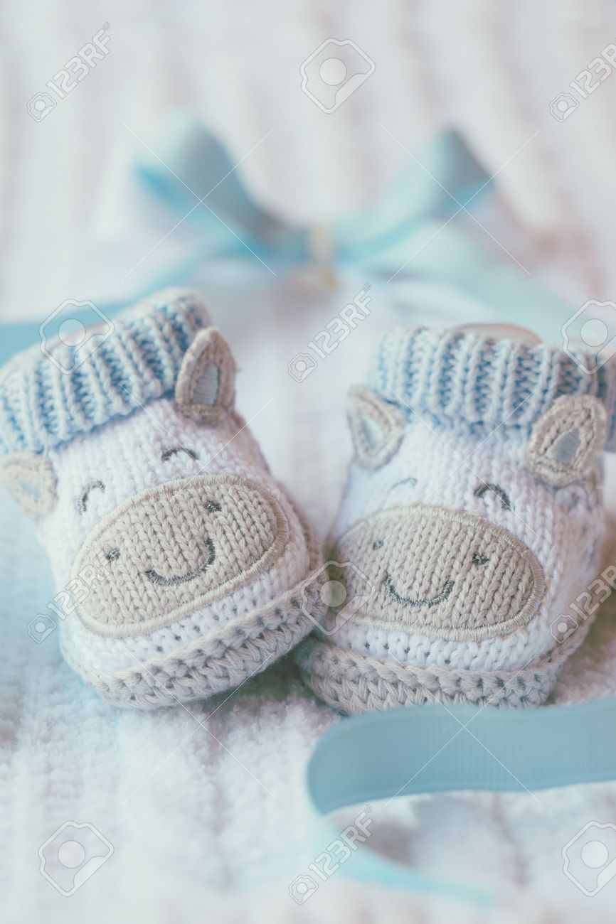 15248700-Knitted-baby-shoes-for-boy-on-a-blue-background-Greeting-card--Stock-Photo.jpg