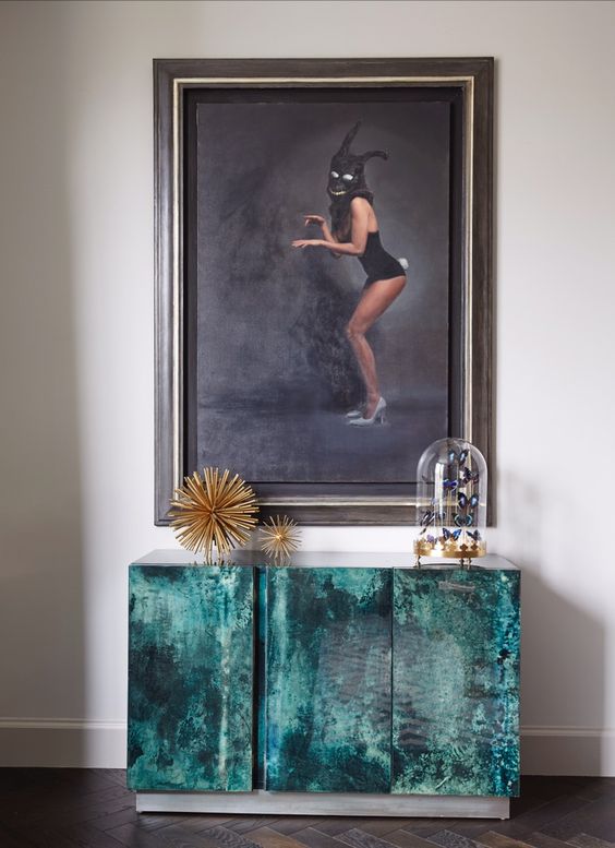 A Sally Jane Fuerst oil painting sits ontop of a Karl Springer goat skin commode from the 70's
