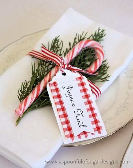 White cotton napkins, sprig of greenery (could use rosemary in a pinch), a candy cane, red  white striped ribbon and a pretty place tag... table setting ideas for Christmas