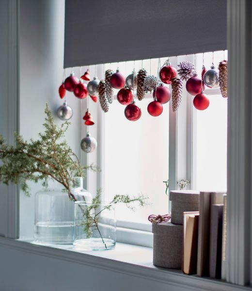 In a window, the bottom of a white curtain is decorated with IKEA DECO ornaments