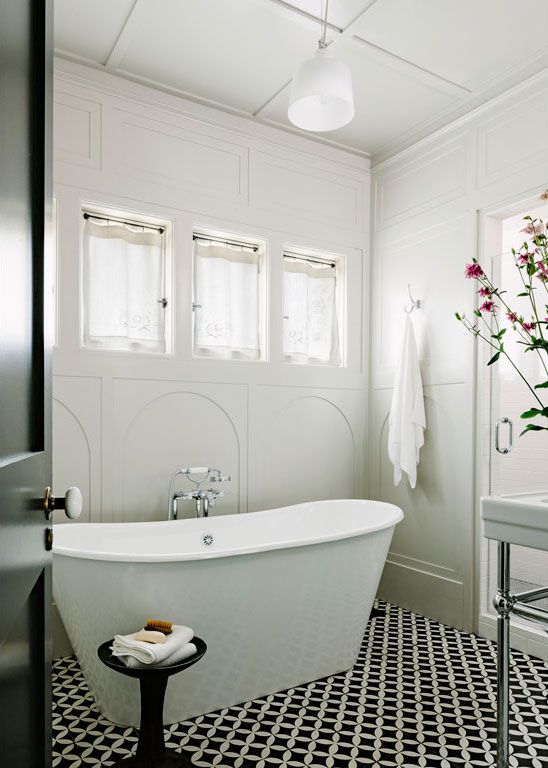 Bathroom with a white standing tub and graphic tiled floors