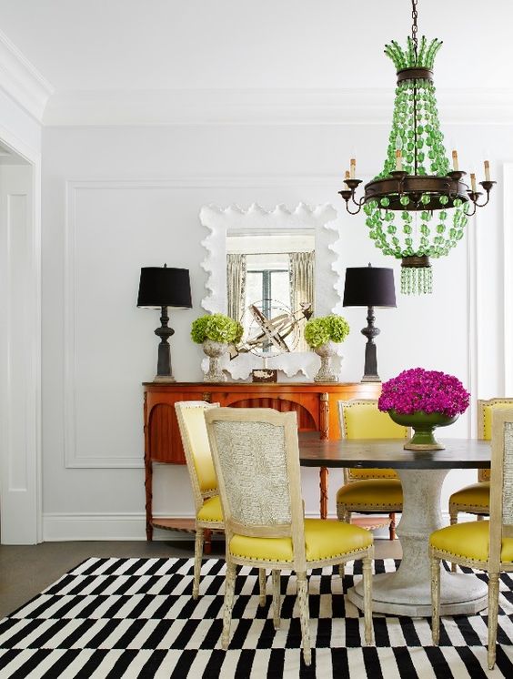 A graphic rug lends lightens the load of a heavy pedestal table paired with French chairs upholstered in yellow leather and backed with faux crocodile. - Photo: Werner Straube / Design: Christine Hughes