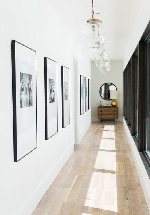 Pendant lights by Arteriors hang in the light-filled hallway | archdigest.com