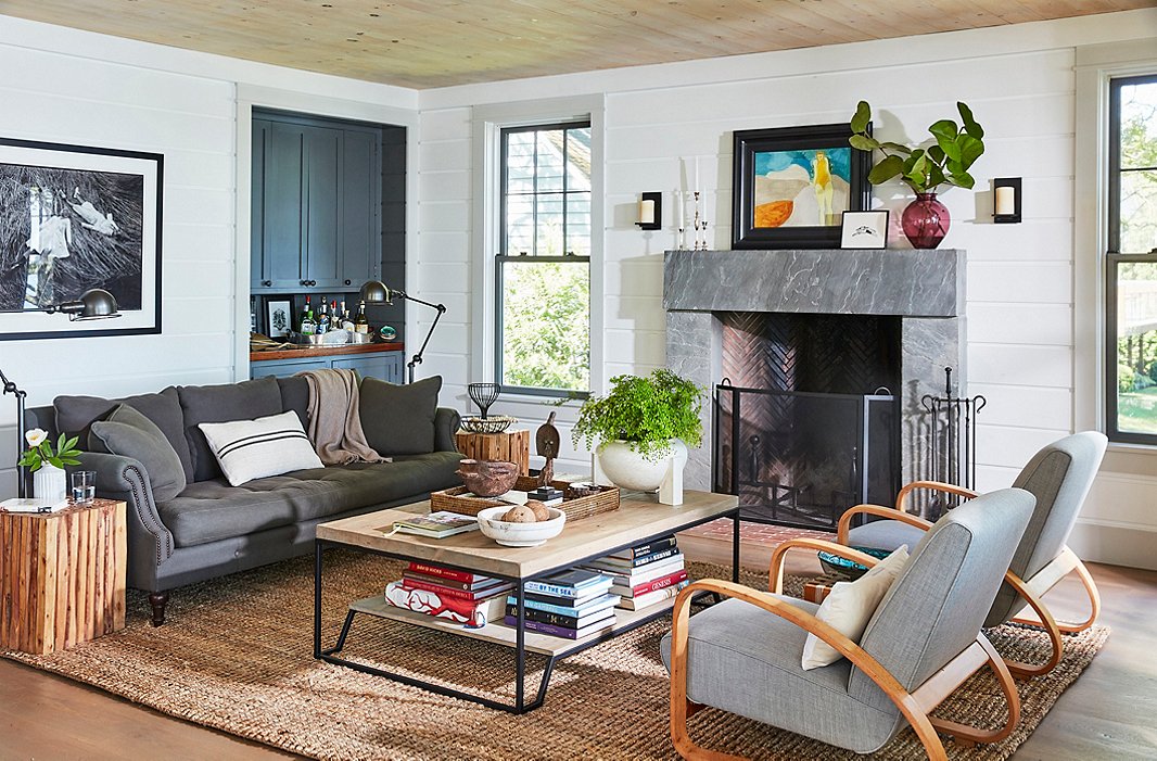 A gray linen sofa and pair of vintage Italian armchairs from Finch Hudson in Hudson, NY, create an inviting gathering spot by the fireplace. On the bluestone mantel, a small finger painting by T.R.âs niece rests alongside another titledÂ The Bather. T.R. found the two-tier coffee table on One Kings Lane.
