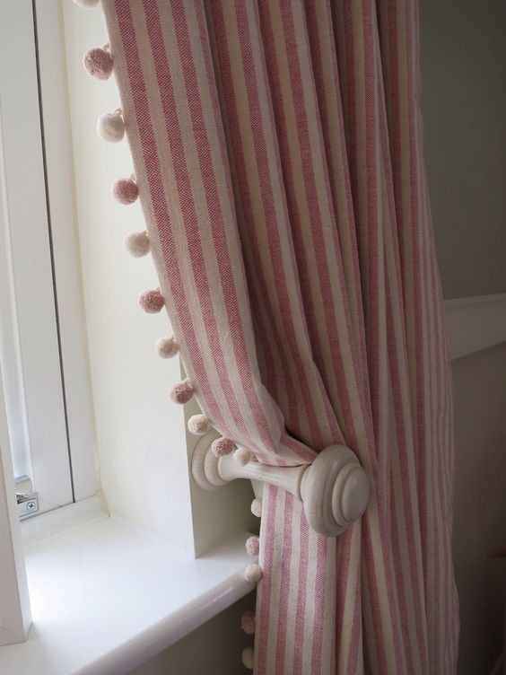 Striped curtains with pom pom trim A pair of full length pencil pleat curtains with a pom pom trim leading edge. Ivory curtain pole and matching holdbacks. Fabric and trim by Susie Watson.  Poles and holdbacks supplied by LJ Curtains.