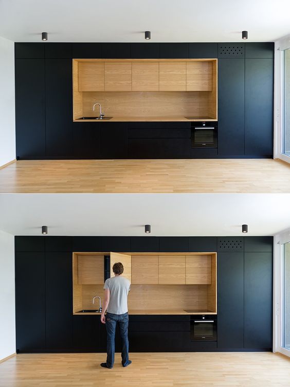 Black and wood as used here are entirely minimalist, with every kitchen item hidden carefully away in recessed cabinets.