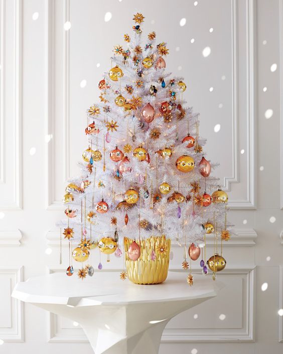 Like an exquisitely turned-out party guest, this white tabletop tree is draped in fancy jewelry; itâs then placed in a faceted gold vase. Metallic pink, copper, and gold ornaments and colorful glass âgemsâ dangleâmany pendant-style, on chainsâfrom the boughs. The chains on the lower branches are longer, emphasizing the dripping-with-jewels effect.