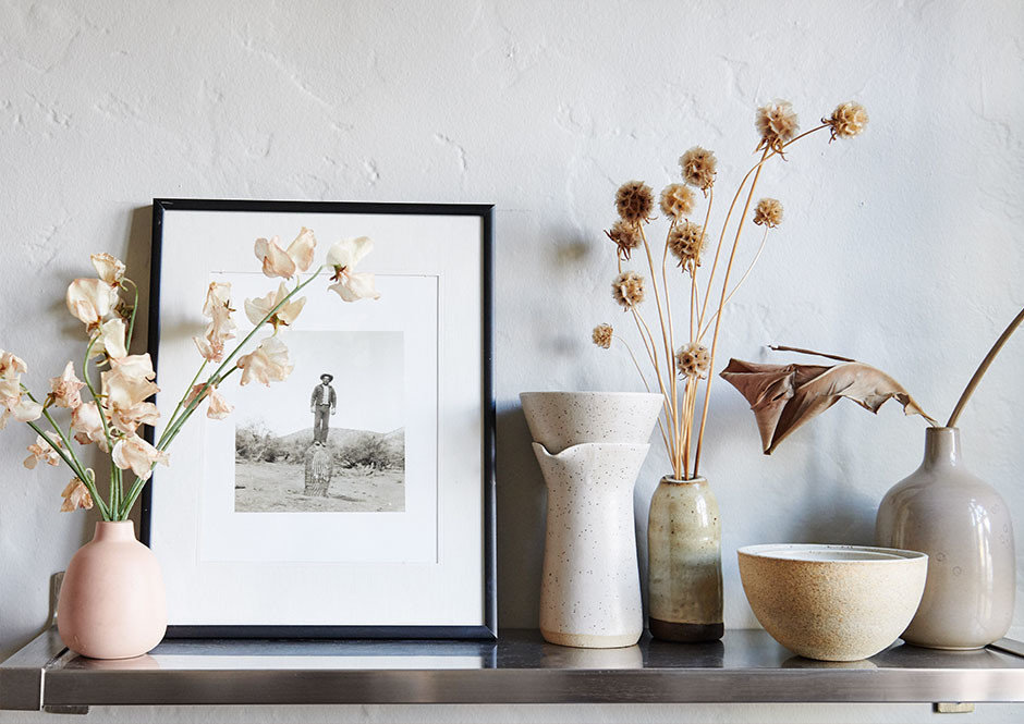 Personal touches — like cuttings from the Marigold workshop and a vintage photograph of Andrés' great-grandfather taken in Patagonia — decorate the open shelves throughout the duo's apartment. Heath Ceramics, Julie Cloutier Ceramics Assorted Vases. 