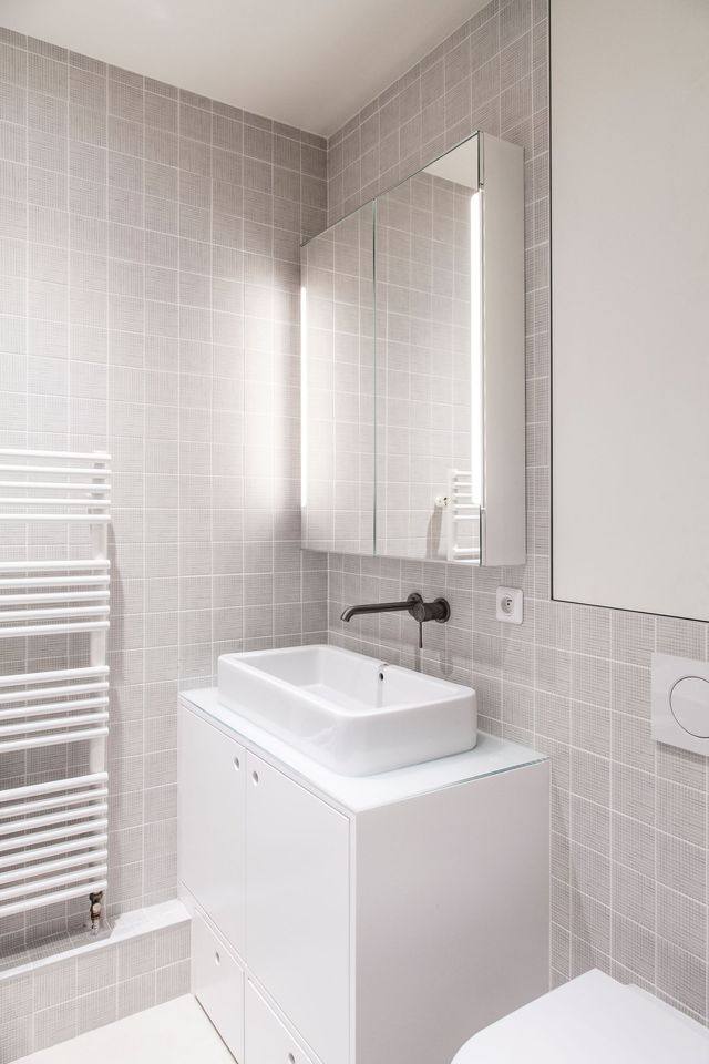 La salle de bains des enfants se compose d'une baignoire, de WC et d'un meuble vasque avec marchepied escamotable. L'architecte a choisi une déco intemporelle : carrelage texturé Inga Sempé et équipement blanc.