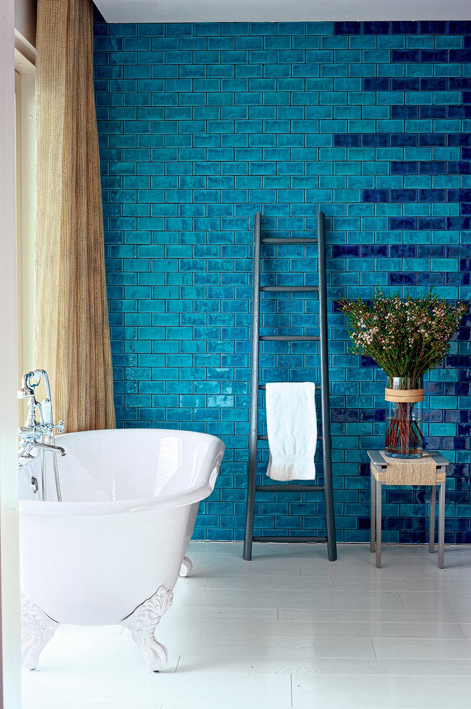 Salle de bain avec baignoire pattes de lion et au murs, des carreaux de cÃ©ramique dÃ©clinant les bleu clair et le bleu doncÃ©